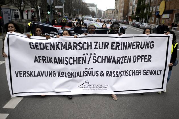 Gedenkmarsch Kolonialgeschichte DEU, Deutschland, Germany, Berlin, 25.02.2024 Demonstranten mit Transparent beim 17. Gedenkmarsch zur Erinnerung an die afrikanischen und schwarzen Opfer von Versklavung Kolonialismus und rassistischer Gewalt Maafa vom Komitee fuer die Errichtung fuer ein afrikanisches Denkmal Kadib in Berlin in Berlin Deutschland . Forderung nach Anerkennung der Verbrechen gegen Schwarze Menschen und Menschen afrikanischer Herkunft unter Einfluss der Black Lives Matter Bewegung. Mehr als 30 Millionen Afrikanerinnen und Afrikaner wurden Opfer von Versklavung und kolonialen Verbrechen. Die von Deutschland an den Herero und Nama begangenen Voelkermorde in Namibia und die Kriegsverbrechen in Tansania im Maji- Maji-Krieg warten i
