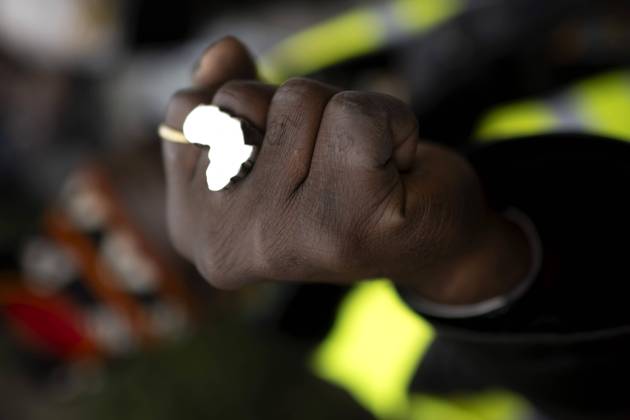 Gedenkmarsch Kolonialgeschichte DEU, Deutschland, Germany, Berlin, 25.02.2024 Demonstrant mit Faust und Ring in Form von Afrika als Symbol der African Black Community beim 17. Gedenkmarsch zur Erinnerung an die afrikanischen und schwarzen Opfer von Versklavung Kolonialismus und rassistischer Gewalt Maafa vom Komitee fuer die Errichtung fuer ein afrikanisches Denkmal Kadib in Berlin in Berlin Deutschland . Forderung nach Anerkennung der Verbrechen gegen Schwarze Menschen und Menschen afrikanischer Herkunft unter Einfluss der Black Lives Matter Bewegung. Mehr als 30 Millionen Afrikanerinnen und Afrikaner wurden Opfer von Versklavung und kolonialen Verbrechen. Die von Deutschland an den Herero und Nama begangenen Voelkermorde in Namibia und di