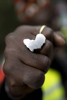Gedenkmarsch Kolonialgeschichte DEU, Deutschland, Germany, Berlin, 25.02.2024 Demonstrant mit Faust und Ring in Form von Afrika als Symbol der African Black Community beim 17. Gedenkmarsch zur Erinnerung an die afrikanischen und schwarzen Opfer von Versklavung Kolonialismus und rassistischer Gewalt Maafa vom Komitee fuer die Errichtung fuer ein afrikanisches Denkmal Kadib in Berlin in Berlin Deutschland . Forderung nach Anerkennung der Verbrechen gegen Schwarze Menschen und Menschen afrikanischer Herkunft unter Einfluss der Black Lives Matter Bewegung. Mehr als 30 Millionen Afrikanerinnen und Afrikaner wurden Opfer von Versklavung und kolonialen Verbrechen. Die von Deutschland an den Herero und Nama begangenen Voelkermorde in Namibia und di