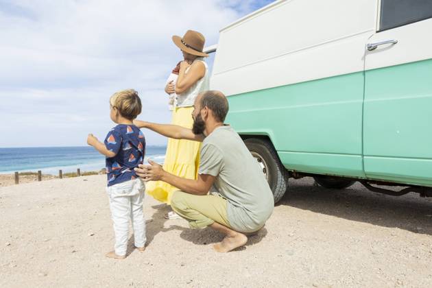 A young family enjoys a serene moment by the sea beside their retro van, embracing the joys of simple travel and togetherness. Model Released JuanAizpuru_ID19709_584473_016 Copyright: xJuanxAizpurux