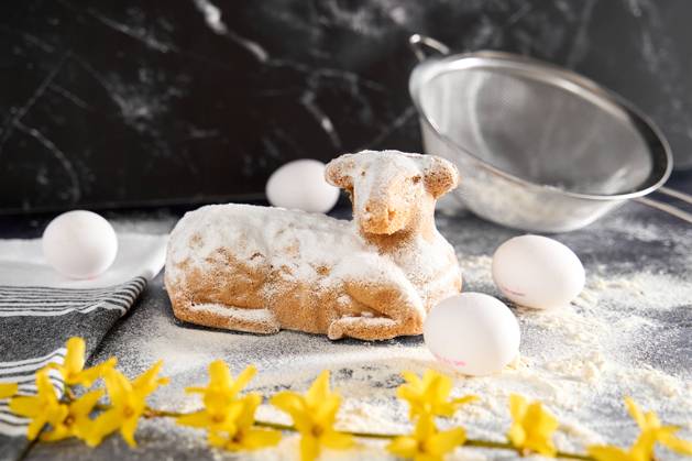 Augsburg, Bavaria, Germany - March 22, 2024: Traditional Easter lamb as a cake for Easter. Baking concept with flour, eggs and fresh yellow flowers