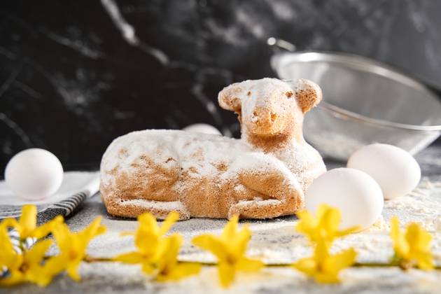 Augsburg, Bavaria, Germany - March 22, 2024: Traditional Easter lamb as a cake for Easter. Baking concept with flour, eggs and fresh yellow flowers