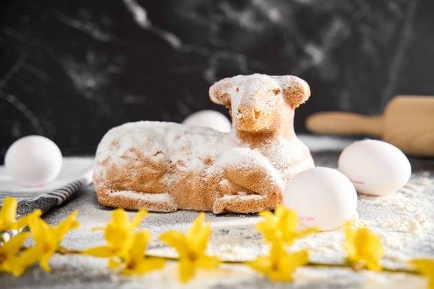 Augsburg, Bavaria, Germany - March 22, 2024: Traditional Easter lamb as a cake for Easter. Baking concept with flour, eggs and fresh yellow flowers