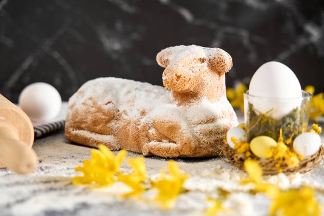 Augsburg, Bavaria, Germany - March 22, 2024: Traditional Easter lamb as a cake for Easter. Baking concept with flour, eggs and fresh yellow flowers