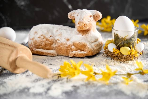 Augsburg, Bavaria, Germany - March 22, 2024: Traditional Easter lamb as a cake for Easter. Baking concept with flour, eggs and fresh yellow flowers