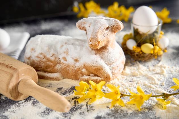 Augsburg, Bavaria, Germany - March 22, 2024: Traditional Easter lamb as a cake for Easter. Baking concept with flour, eggs and fresh yellow flowers