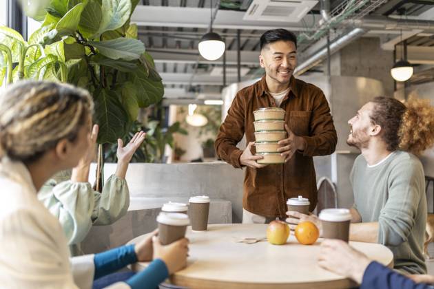 Smiling businessman holding stack of containers at lunch break in office model released, Symbolfoto property released, JCCMF11304
