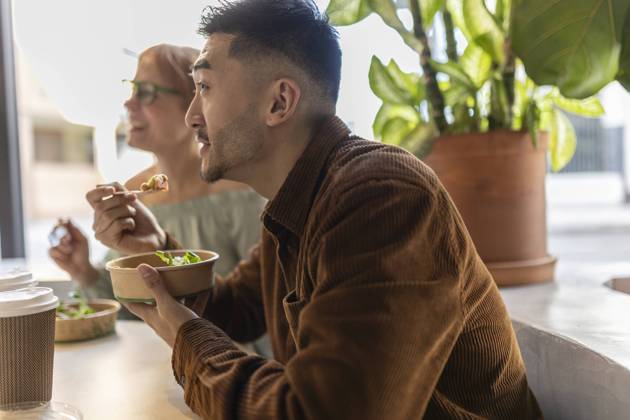 Businessman eating lunch with colleague at office model released, Symbolfoto property released, JCCMF11309