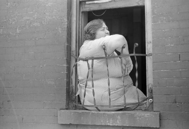EVANS: NEW YORK, 1938. A woman sitting in window of her apartment on 61st Street between 1st and 3rd Avenues, New York, New York. Photograph by Walker Evans, 1938.  Copyright: xGRANGERx xGRANGERx 0268350
