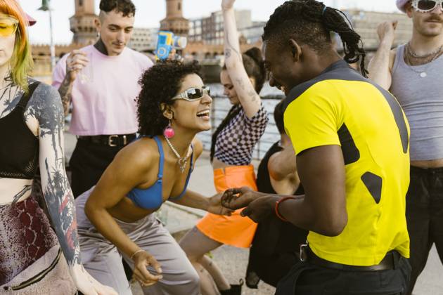 Happy non-binary person wearing sunglasses and dancing with friends in city Germany, Berlin, model released Copyright: xMaskotx , MA108330 MA108330