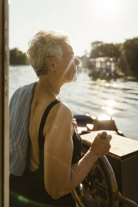 Senior woman steering houseboat on vacation Germany, Berlin, model released, property released Copyright: xMaskotx , MA108718 MA108718