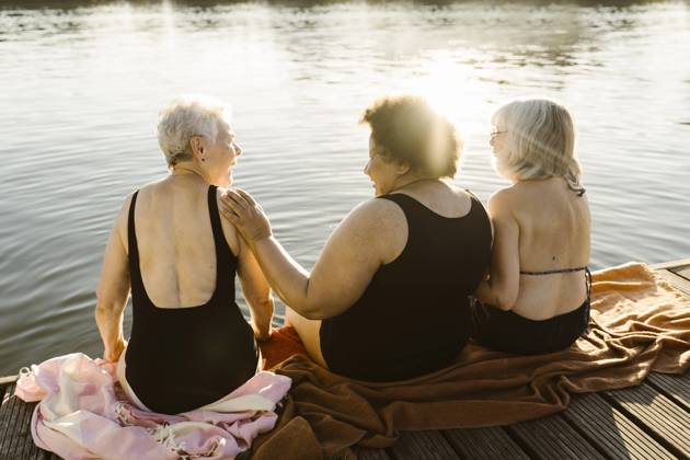 Happy elderly female friends talking while sitting on houseboat near lake on vacation Germany, Berlin, model released, property released Copyright: xMaskotx , MA108725 MA108725