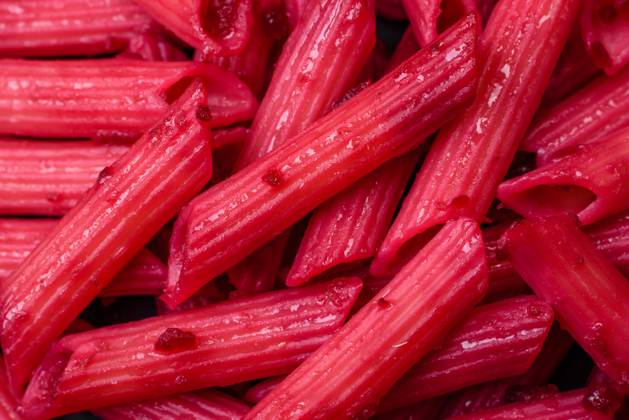 Delicious penne pasta with beets, cheese, salt and spices Delicious penne pasta with beets, cheese, salt and spices on a dark concrete background Copyright: xZoonar.com TetianaxChernykovax 21432790