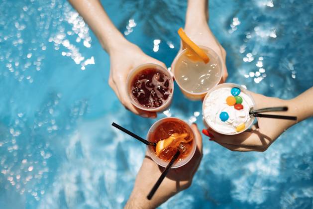 Close-up of female and male hands holding glasses with iced cocktails and clinking them. Friends make festive toast with delicious drinks against background of clear blue pool water. Close-up of female and male hands holding glasses with iced cocktails and clinking them. Friends make festive toast with delicious drinks against background of clear blue pool water. Party, vacation. Copyright: xZoonar.com DashaxPetrenkox 21475956