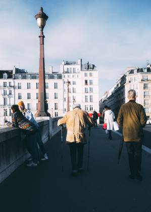 Travelpictures Paris Paris, 02 04 2024 Travelpictures, An older man walks across a bridge with walking sticks