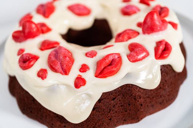 Red velvet bundt cake Freshly baked red velvet bundt cake with chocolate lips and hearts over cream cheese glaze for Valentine s Day. Copyright: xArinaxHabich RECORD DATE NOT STATED