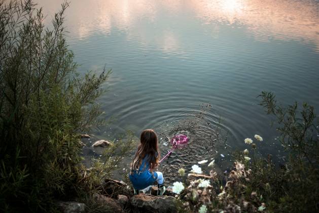 IMAGO Creative, Jahreszeit Sommer, Sommerferien Young girl splashing water in lake at sunset Wooster, Ohio, United States CR_JOKU240507CB-1422584-01 ,model released, Symbolfoto