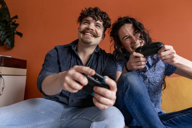 IMAGO Creative, Lifestyle, Gaming Cheerful couple playing video game at home model released, Symbolfoto property released, JOSEF24254