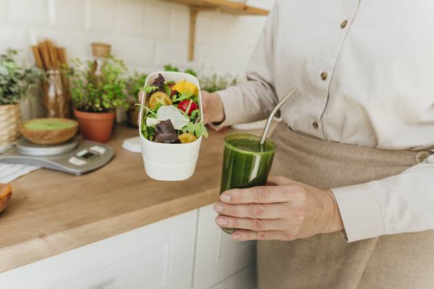 Woman holding salad and detox juice in kitchen at home model released, Symbolfoto property released, YTF00886