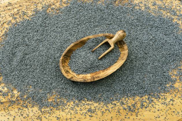 Poppy seed in Wooden bowl and at Holzschaeufelchen Poppy Seeds in a Wooden Bowl and ON a Wooden Scoop BLWS709981 Copyright: xblickwinkel Steidix