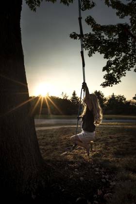 IMAGO Creative, Jahreszeit Sommer, Sommerferien Little girl long blonde curls swinging in bright sunlight Wooster, Ohio, United States CR_JOKU240509-1420068-01 ,model released, Symbolfoto