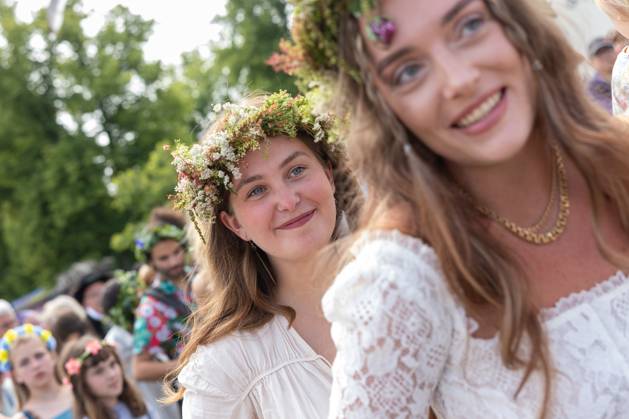 Mittsommer in Schweden Malmoe, Schweden - 21.6.2024: Menschen schmücken ihre Haare mit Blumenkränzen und feiern und tanzen um einen Midsommarstang Mittsommer im Folkets Park in Malmoe in Schweden.