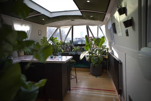 Love plants? Stay in London™s first live-in terrarium boat this summer Story from Jam Press (Terrarium Boat) Pictured: The living room. Love plants? Stay in London™s first live-in terrarium boat this summer Are you a plant lover? A water babe? Well, now you can take both to the next level with a stay on a ˜terrarium boat . Moored on a canal in Hackney, London, this life-size ecosystem is made for those who want to get close to nature. The 48.3 sq m boat is decked out with 150 verdant houseplants - making it a perfect live-in oasis. Terrariums are more commonly known to be small, sometimes big, glass enclosures filled with plants, stones and mosses. But this one is a floating, green sanctuary. The two-guest property is co Copyright: xJamxPress @thefloatingterrarium