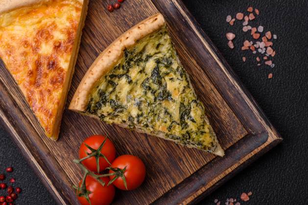 Delicious crispy quiche cut into slices with cheese, broccoli, tomatoes Delicious crispy quiche cut into slices with cheese, broccoli, tomatoes, salt, spices and herbs on a dark concrete background Copyright: xZoonar.com TetianaxChernykovax 21798930