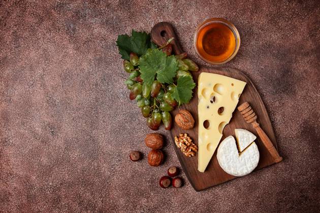Cheese With Big holes, emmental, maasdam, Brie cheese, ON a Cutting board, With grapes and honey, nuts, appetizer to wine, Top View Copyright: imageBROKER GalinaxDidebashvili ibxgai10481134.jpg RECORD DATE NOT STATED