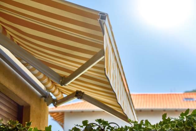 IMAGO Creative, Jahreszeit Sommer, Hitze Nago-Torbole, Lake Garda, Italy - 15 July 2024: Awning on a vacation apartment on Lake Garda offers optimum sun protection and increases outdoor living comfort. Awning provides pleasant shade and a cozy ambience on the terrace in Italy