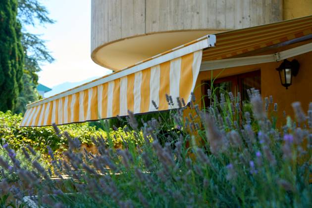 Nago-Torbole, Lake Garda, Italy - 15 July 2024: Awning on a vacation apartment on Lake Garda offers optimum sun protection and increases outdoor living comfort. Awning provides pleasant shade and a cozy ambience on the terrace in Italy