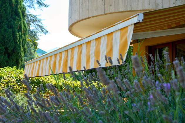 Nago-Torbole, Lake Garda, Italy - 15 July 2024: Awning on a vacation apartment on Lake Garda offers optimum sun protection and increases outdoor living comfort. Awning provides pleasant shade and a cozy ambience on the terrace in Italy