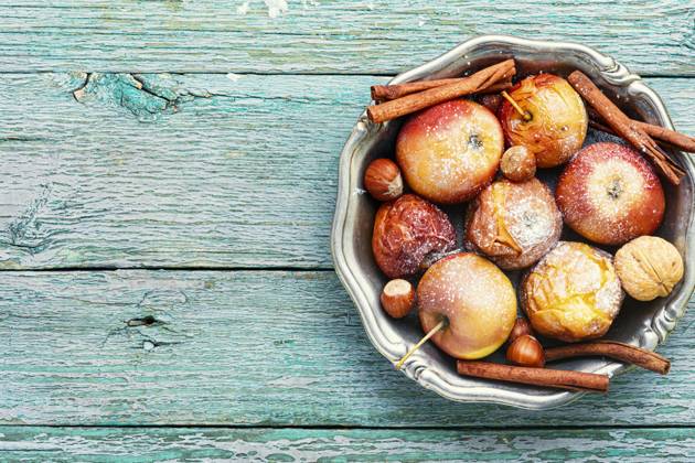 Fruit dessert baked red apples on wooden table.Christmas food. Baked apples on plate ,model released, Symbolfoto