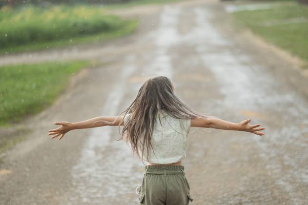 Long hair girl with arms outstretched standing and enjoying rain at back yard model released, Symbolfoto, ANAF03336