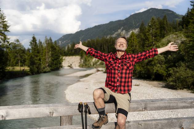 Cheerful man enjoying a hike in the mountains on a sunny day near a river in Germany. model released, Symbolfoto, DIGF21470