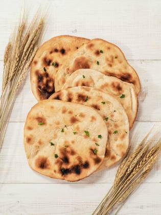 IMAGO Creative, Food, Brot, Naan naan flatbreads on white wood, copy space, top view, Fresh naan bread on white wooden background with copy space. Top view of several perfect naan flatbreads on metal tray. Vertical, Fresh naan bread on white wooden background with copy space. Top view of several perfect naan flatbreads on metal tray. Vertical, 19.07.2023, Copyright: xFascinadorax Panthermedia35535988.jpg
