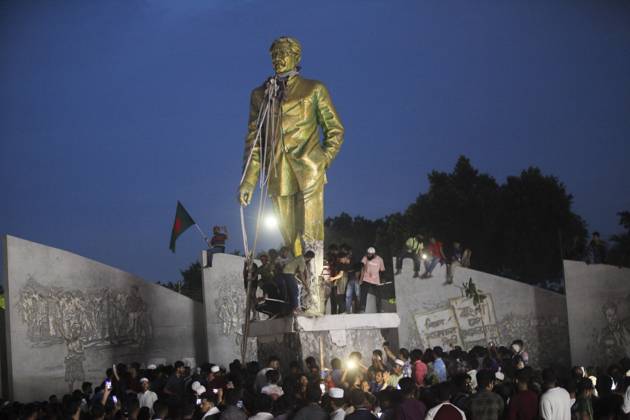 August 5, 2024, Dhaka, Dhaka, Bangladesh: Anti-government protestors climbs atop a statue of Sheikh Mujibur Rahman, Bangladesh s founding father and parent of the country s ousted Prime Minister Sheikh Hasina, in Dhaka on August 5, 2024. Bangladeshi Prime Minister Sheikh Hasina s 15-year rule ended on August 5, as she fled after more than a month of deadly protests as the military announced it would form an interim government. Dhaka Bangladesh - ZUMAj163 20240805_zip_j163_005 Copyright: xAbuxSufianxJewelx