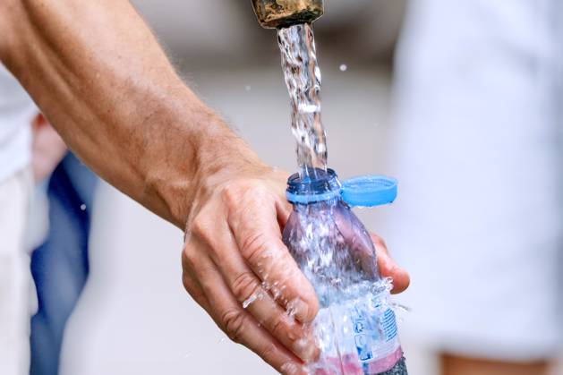 Man fills his water bottle with fresh drinking water, fountain at Marienplatz, midsummer, Munich, August 2024 Germany, Munich, August 2024, a man fills his water bottle with fresh drinking water at the fountain, drinking is particularly important i