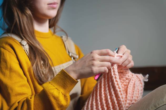 Weibliche Hände in Nahaufnahme, häkelnde Kleidung auf dem Sofa zu Hause, handgemacht Female hands close-up, crocheting clothes on the sofa at home, handmade Copyright: imageBROKER IanxIankovskii ibxiqx09619281.jpg ,model released, Symbolfoto ,property released