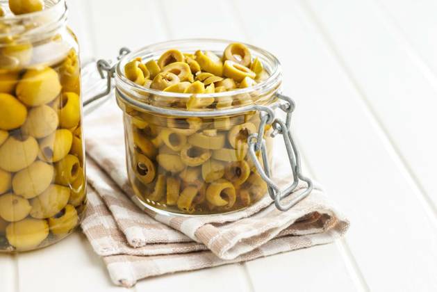 Sliced pickled green olives in brine in jar on white table., Sliced pickled green olives in brine in jar on a white table., Sliced pickled green olives in brine in jar on a white table., 07.08.2024, Copyright: xjirkaejcx Panthermedia37668654.jpg