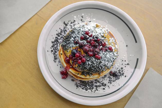 Pfannkuchen mit Erdnussbuttercreme, Beeren, Streuseln und Puderzucker auf einem Teller und einem Holztisch, süßes Brunch oder Dessertgericht, Draufsicht von oben, Kopierraum, gewählter Fokus, enge Tiefenschärfe Pancakes with peanut butter cream, berries, crumble and icing sugar on a plate and a wooden table, sweet brunch or dessert dish, top view from above, copy space, selected focus, narrow depth of field Copyright: imageBROKER MarenxWinter ibxiqx11040469.jpg