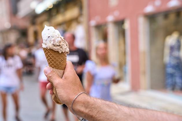 IMAGO Creative, Jahreszeit Sommer, Hitze Corfu, Greece - September 4, 2024: A hand holds an ice cream in a waffle