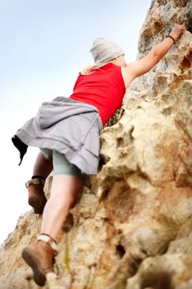 Woman on cliff, rock climbing and hiking adventure in mountain with nature, freedom and power. Travel, girl trekking and hanging, strong person in countryside on natural outdoor journey with fitness model released property released Copyright: xwww.peopleimages.comx