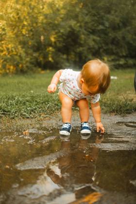 Toddler putting hands and feet in mud puddle Raleigh, North Carolina, United States R_XMBF241014-1562486-01 ,model released, Symbolfoto