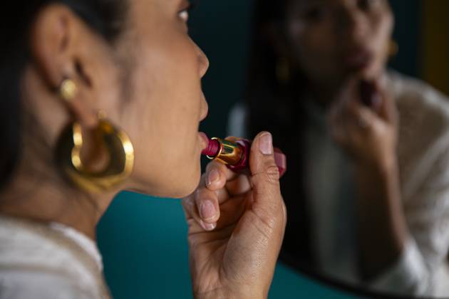 Woman applying lipstick in front of mirror model released, Symbolfoto property released, PCLF01431