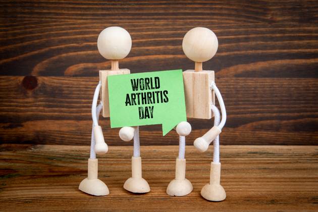 World Arthritis Day 12 October. Green speech bubble with text on wood texture background. Copyright: xEdgarsxSermulisx