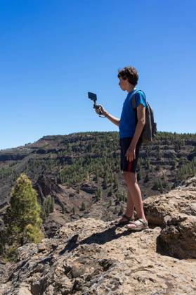  A teenager uses a three-axis image stabilizer to film a natural mountain landscape on a smartphone camera. Gran Canaria. Canary Islands. Spain., A teenager uses a three-axis image stabilizer to film a natural mountain landscape on a smartphone camera. Gran Canaria. Canary Islands. Spain., A teenager uses a three-axis image stabilizer to film a natural mountain landscape on a smartphone camera. Gran Canaria. Canary Islands. Spain. model released, Symbolfoto , 27.09.2024, Copyright: xBuschmenx Panthermedia37979272.jpg
