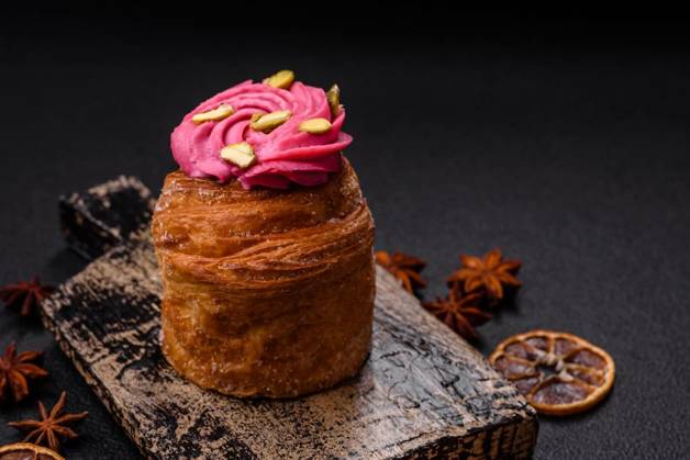 Sweet craffin or panettone garnished with raspberry and pistachio flavored cream, Sweet craffin or panettone garnished with raspberry and pistachio flavored cream on a dark concrete background, Sweet craffin or panettone garnished with raspberry and pistachio flavored cream on a dark concrete background, 17.10.2024, Copyright: xTan4ikx Panthermedia38117169.jpg