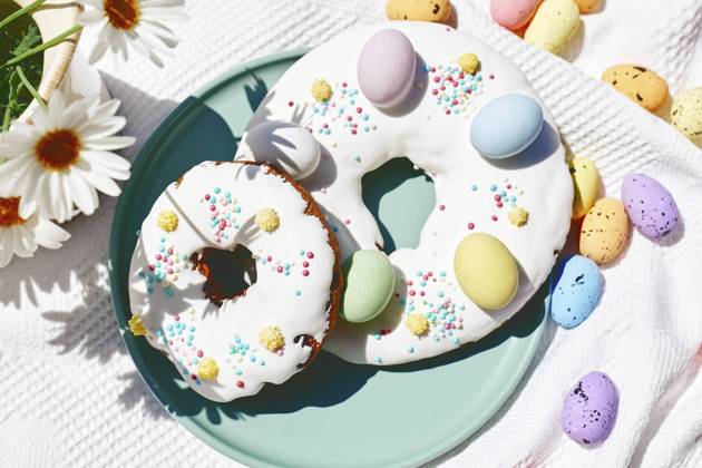 Easter doughnuts decorated with colorful chocolate eggs on table, CATF00555