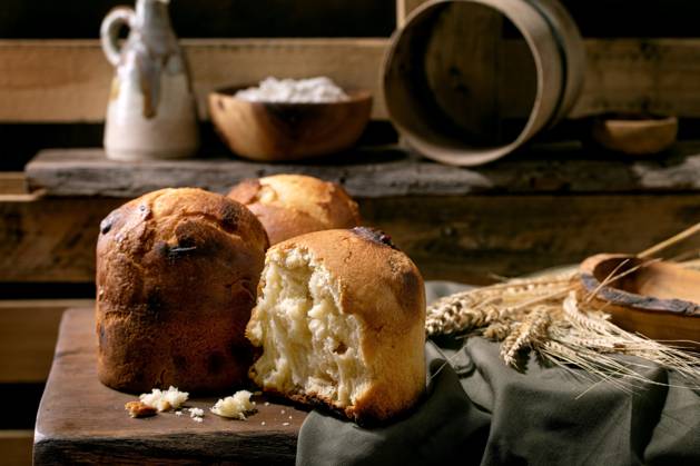 Hausgemachtes traditionelles italienisches Brioche-Weizenbrot ganz und halb Homemade traditional italian brioche wheat bread with cheese inside, whole and half. Standing on wooden table in rustic kitchen with kitchen utensil at background. Copyright: xZoonar.com NATASHAxBREENx 22664192